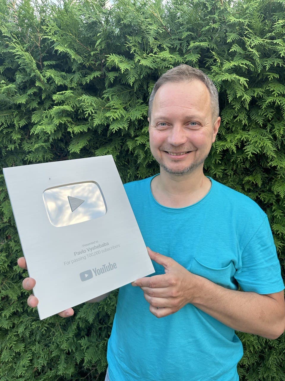 Andrej Slabinsky holding a YouTube Silver Creator Award plaque outdoors, Maribor, 7 July 2023