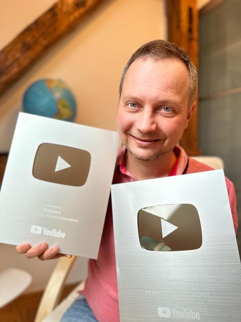 Andrej Slabinsky holding two YouTube Silver Creator Award plaques indoors, 9 December 2023